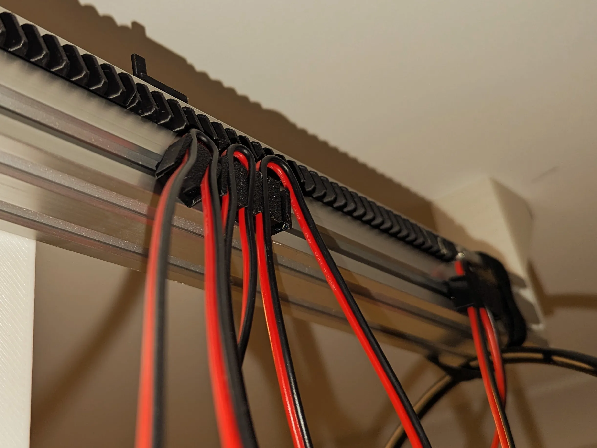 Cable clips and looped wire running alongside the extrusion